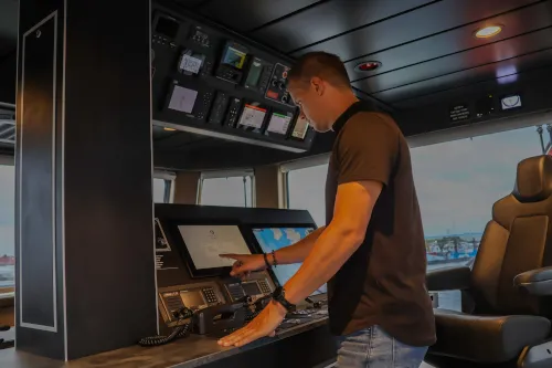 Engineer van Marble bedient een touchscreen aan de brugconsole van een schip