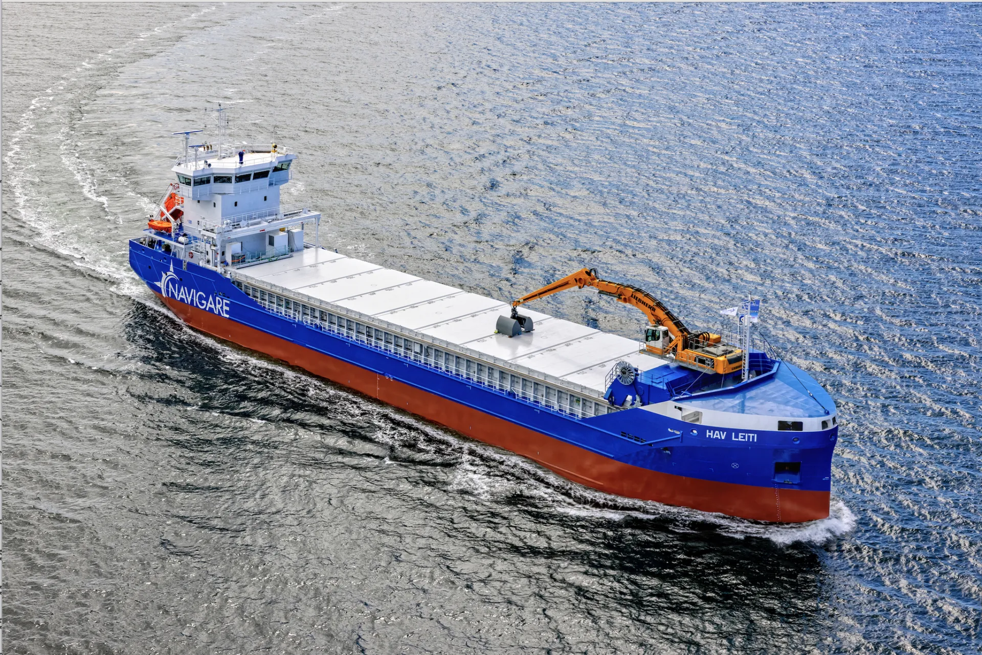 Aerial view of Navigare cargo vessel Hav Leiti with self-unloading crane under way
